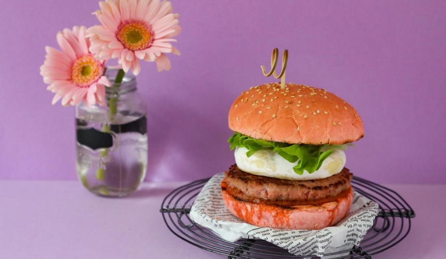 Panino rosa con hamburger, tomino e salsa di pomodori secchi